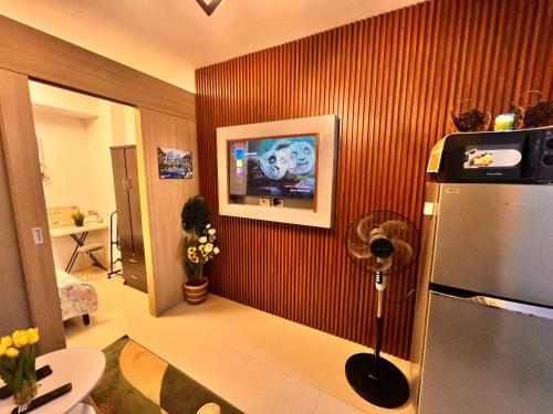 a living room with a refrigerator and a tv at Yam Staycation Shore Residences in Manila