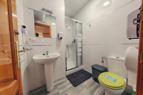 a small bathroom with a sink and a toilet at Charming Nerja Hostel in Nerja