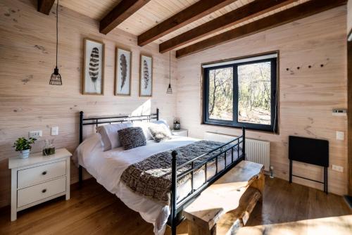 a bedroom with a bed in a room with wooden walls at Cabañas Vista a Corralco in Malalcahuello