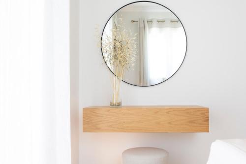 a round mirror on a shelf in a bathroom at Adria Luxury Apartments in Nydri