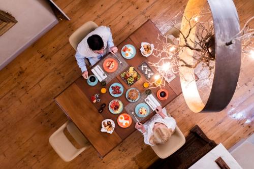 due persone sedute a un tavolo con cibo di Oia Mansion a Oia