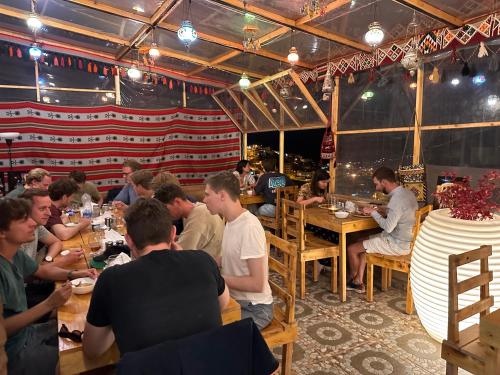 a group of people sitting at tables in a restaurant at Petra Desert Dream Hotel in Wadi Musa