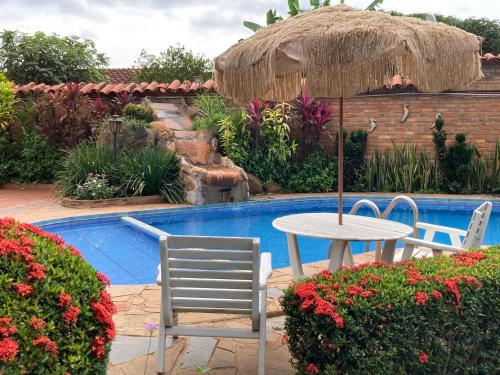 a table and chairs next to a small pool at Apart-Hotel San Ignacio-Boutique 5 Estrellas in San Ignacio de Velasco