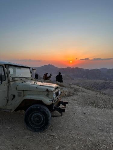 a truck parked on top of a hill with a sunset at Petra Desert Dream Hotel in Wadi Musa