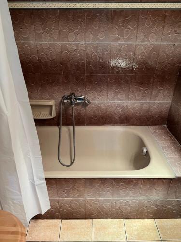 a bath tub with a shower in a bathroom at VALANTIS APARTMENT in Kavála