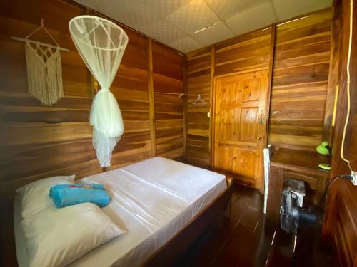 um quarto com uma cama num quarto de madeira em True Nature Jungle House em Bastimentos