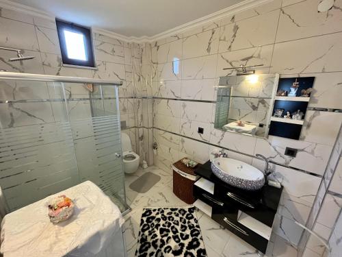 a bathroom with a glass shower and a sink at Greenland Villa Premium 61 in Trabzon