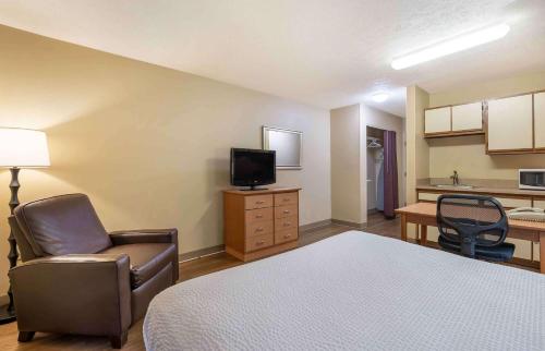 a room with a bed and a chair and a kitchen at Studio 6 Extended stay Indianapolis, IN - North Carmel in Carmel