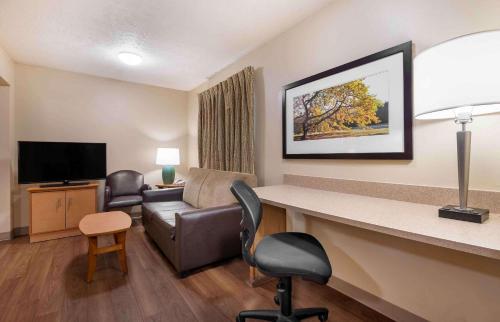 a hotel room with a waiting area with a couch and a television at Studio 6 Extended stay Indianapolis, IN - North Carmel in Carmel