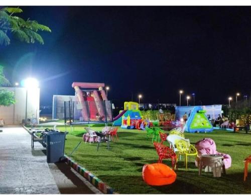 a park with chairs and tables and a playground at night at شاليه للايجار 3 غرف مكيفات بقرية جراند هيلز الساحل الشمالى بإطلاله مباشره على البول in Qaryat Shurūq
