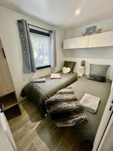 une chambre avec deux lits et une fenêtre dans l'établissement Tiny house famille nature cap ferret, à Claouey