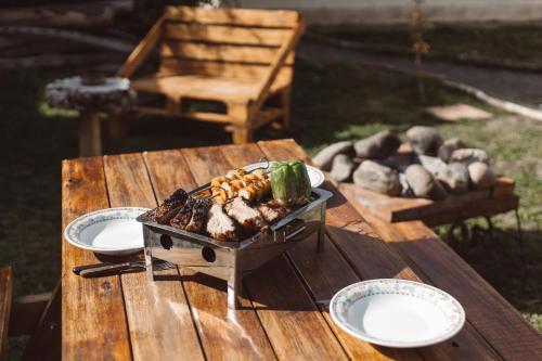 einen Grill auf einem Holztisch mit Essen drauf in der Unterkunft Hostel House 64Bigüa in El Calafate