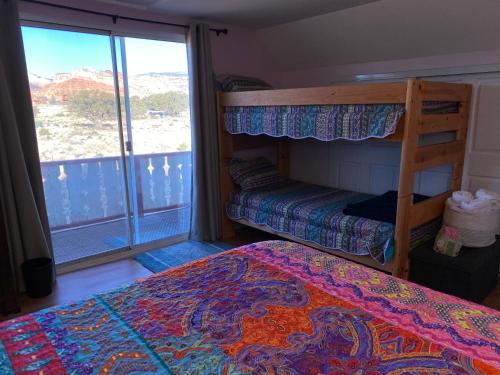a bedroom with two bunk beds and a balcony at Sandcreek Cottage / Fabulous Views on Five Acres in Torrey