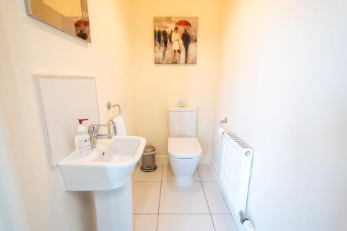 a bathroom with a sink and a toilet at Serene Sands in Felixstowe