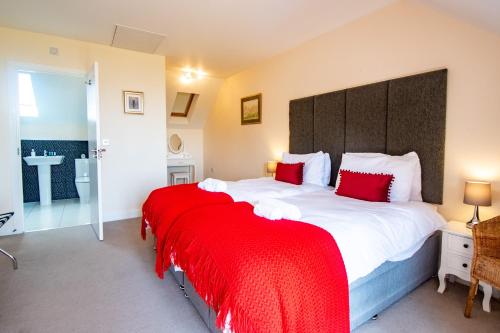 ein Schlafzimmer mit einem großen Bett mit einer roten Decke in der Unterkunft Serene Sands in Felixstowe