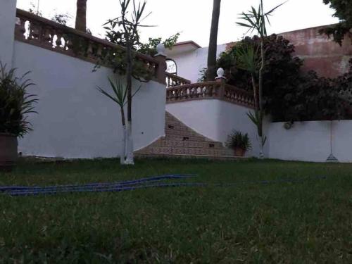 a house with a staircase and a grass yard at Villa calme a tamuda bay médique region de tetuan in M'diq