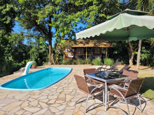 um pátio com uma mesa e cadeiras e uma piscina em Cantinho do marinheiro em Paraty