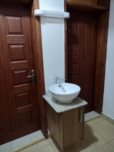 a bathroom with a white sink on a counter next to a door at The Arches Accola in Nairobi