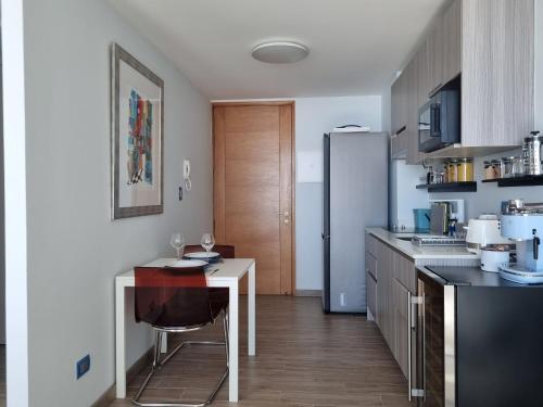 una cucina con tavolo e frigorifero di Antofagasta de Ensueño-SOLO ADULTOS ad Antofagasta