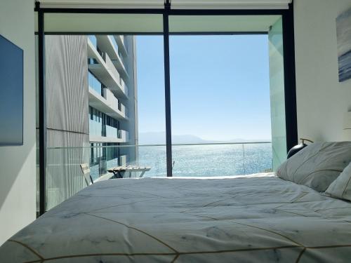 - une chambre avec un lit et une vue sur l'océan dans l'établissement Antofagasta de Ensueño, à Antofagasta