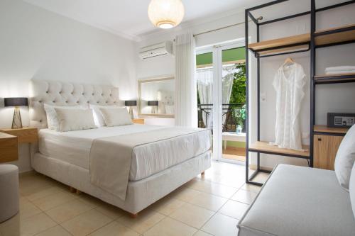 a white bedroom with a large bed and a window at Adria Luxury Apartments in Nydri