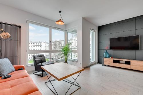 a living room with a couch and a tv at Sleepy3city Apartments Batorego 9 in Gdynia