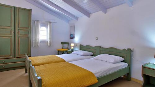 a bedroom with two beds and a window at Casa Andriana in Vragkaniótika