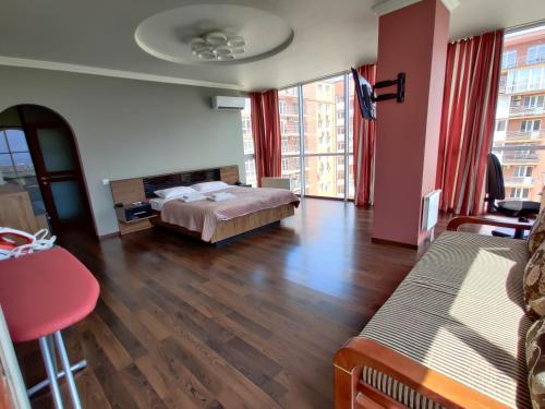ein Hotelzimmer mit einem Bett und einem großen Fenster in der Unterkunft Micromegas apartments in Czernowitz