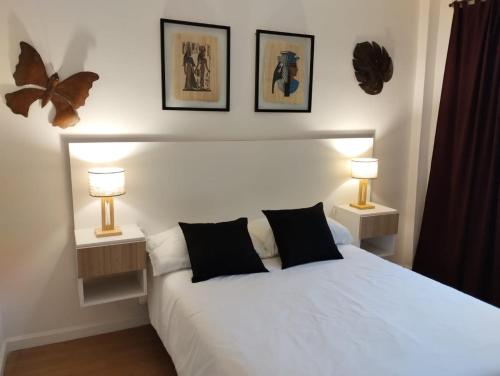 1 dormitorio con 1 cama blanca y 2 lámparas. en Humboldt 2 en Buenos Aires