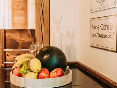 a bowl of fruit on a counter with a melon at Tauernlodge Krimml 1A in Krimml