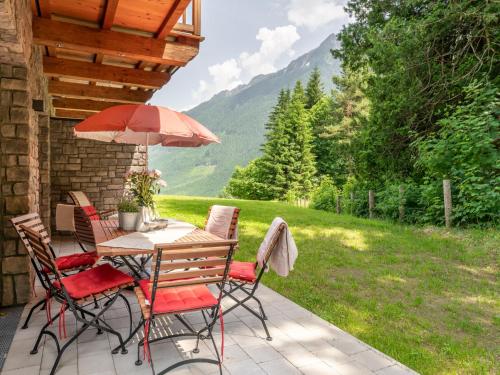 a table and chairs with an umbrella on a patio at Tauernlodge Krimml 1A in Krimml