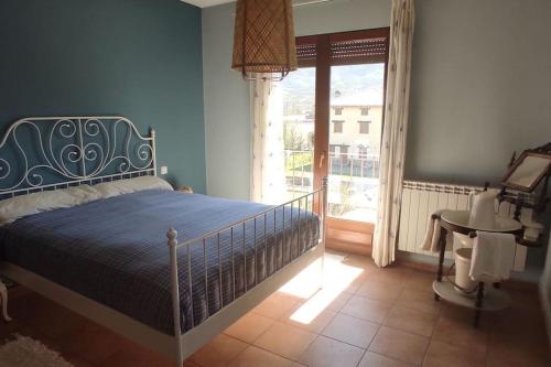 1 dormitorio con cama, ventana y mesa en La casa del fresno, en Pinilla del Valle