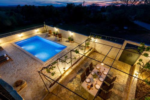 Seven Olives Guest House with heated pool near Krka waterfalls في Planjane: اطلالة علوية على مسبح في الليل