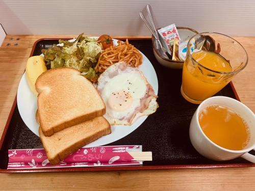 a plate of food with a sandwich and salad and a drink at Guest House Isa in Motobu
