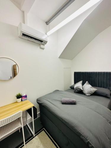 a bedroom with a bed and a table and a mirror at Canopy Aldgate in London