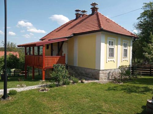 a small house with a red roof in a yard at Medjedovica Brdo Godovik in Godovik