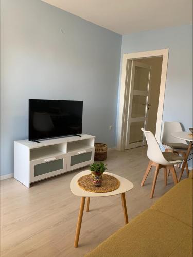 a living room with a flat screen tv and a table at Popi in Budva