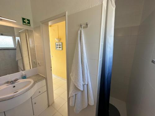 a bathroom with a sink and a shower with a towel at Ceu Azul - Elevated apartment with stunning views and big garden - Somewhere Special in Tavira