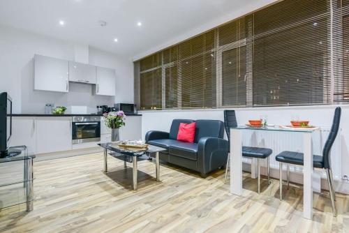 cocina y sala de estar con sofá azul y mesa en Southwark & Bermondsey nest Penthouse apartment en Londres