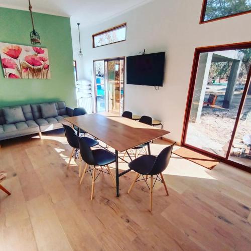 a room with a table and chairs and a flat screen tv at Cabañas Nonito in Pozo Almonte