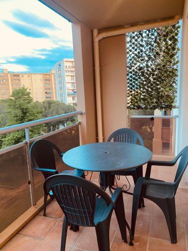 a table and chairs on a balcony with a window at Lisandrina in Ajaccio