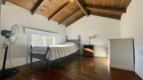 een slaapkamer met een bed in een kamer met houten plafonds bij Hermosa casa en Tafí del Valle! in Tafí del Valle