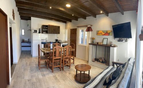 cocina y sala de estar con mesa, sillas y chimenea en Hermosa casa en Tafí del Valle! en Tafí del Valle