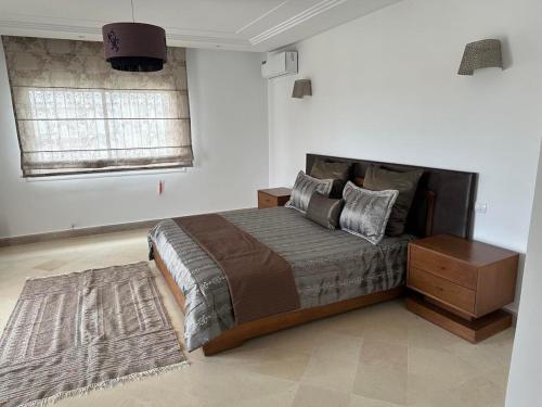 a bedroom with a large bed and a night stand at La superbe villa à Kélibia la blanche in Kelibia