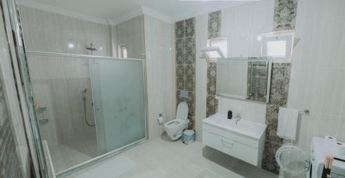 ein Bad mit einer Dusche, einem WC und einem Waschbecken in der Unterkunft DES VILLA Trabzon in Trabzon