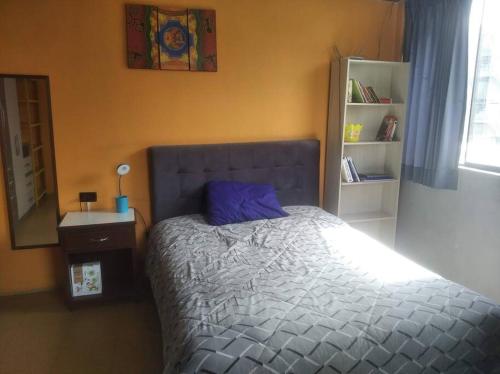 a bedroom with a bed with a blue pillow on it at Jack Appart (departamento 2 cuartos y terraza) in Arequipa