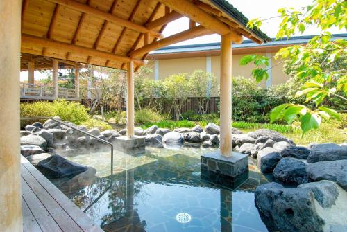 einen Pool in einem Garten mit einer hölzernen Pergola in der Unterkunft Ooedo Onsen Monogatari Urayasu Mangekyo in Urayasu