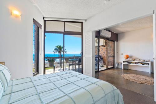 une chambre avec un lit et une vue sur l'océan dans l'établissement 2 bedrooms 2 baths with balcony and ocean views, across from ocean, à Alexandra Headland