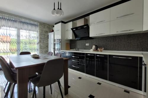 a kitchen with a table and chairs in a room at Amazing Villa with pool nearby Shtime - Ferizaj in Ferizaj