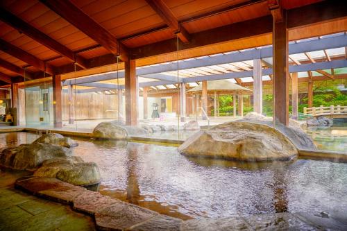 ein großes Gebäude mit einem Teich mit Steinen darin in der Unterkunft Ooedo Onsen Monogatari Urayasu Mangekyo in Urayasu